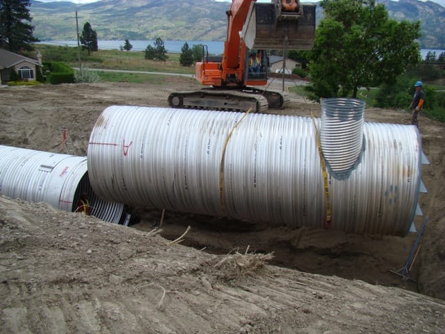 Stormwater retention system of corrugated metal pipes lowers into place