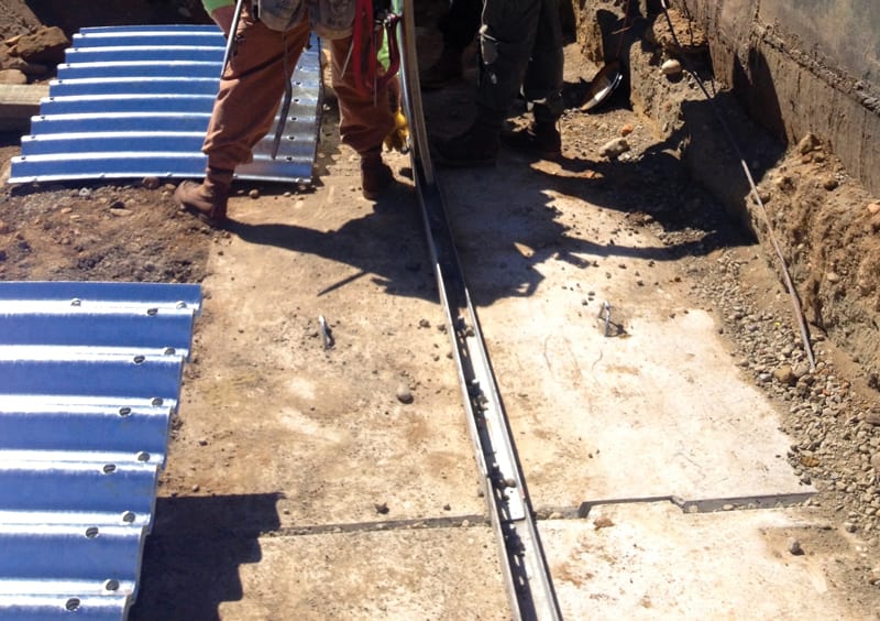 Precast concrete footing with metal base channel